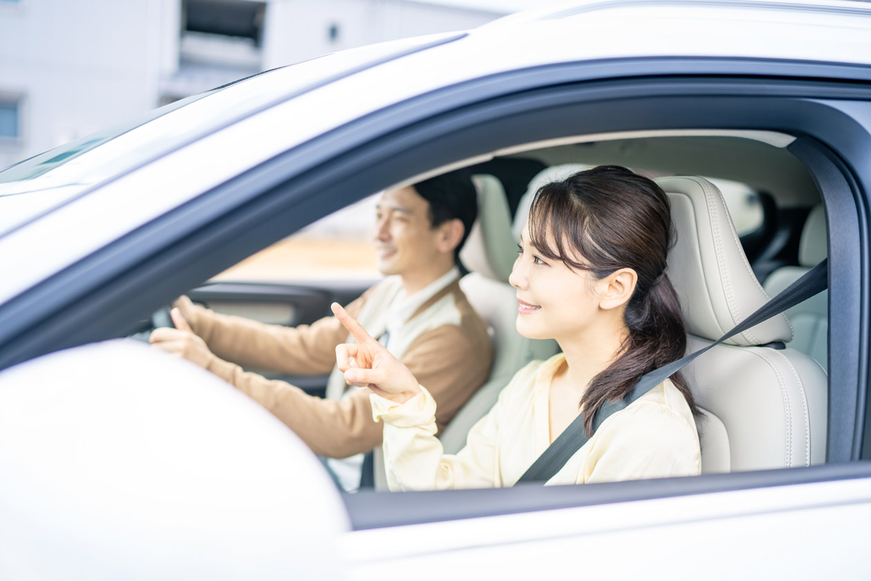 笑顔で運転をする男女